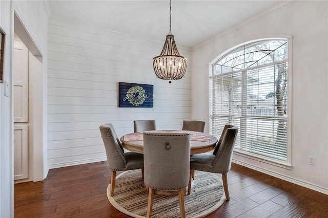 dining room with an inviting chandelier, crown molding, dark wood-style floors, and baseboards