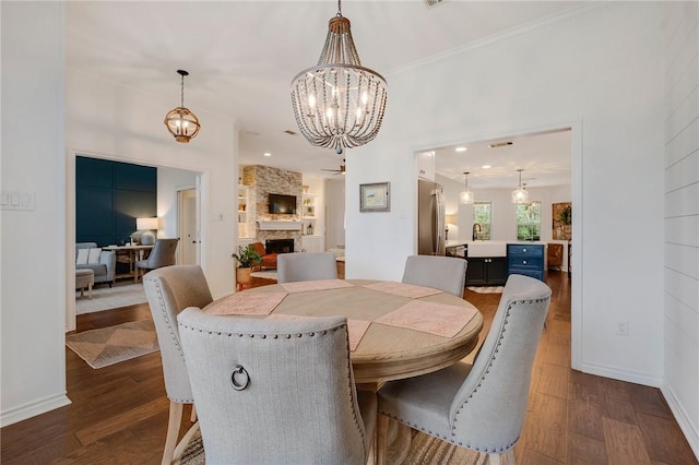 dining area with a fireplace, baseboards, and dark wood-style flooring