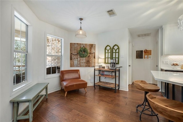 living area featuring dark wood-style floors, visible vents, and baseboards