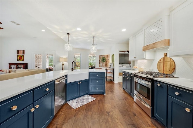 kitchen with light countertops, white cabinets, stainless steel appliances, blue cabinets, and a sink