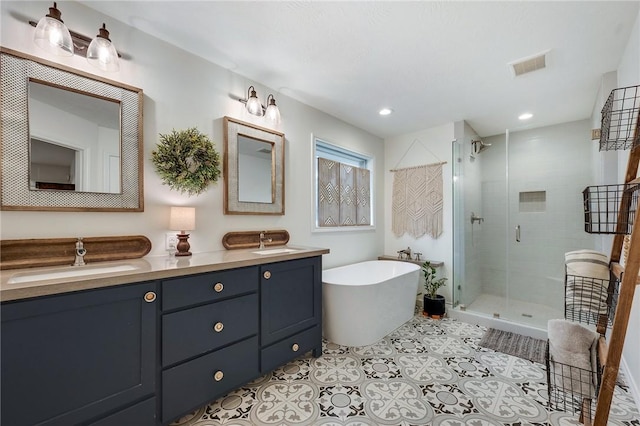 full bath with tile patterned floors, visible vents, a stall shower, and a sink