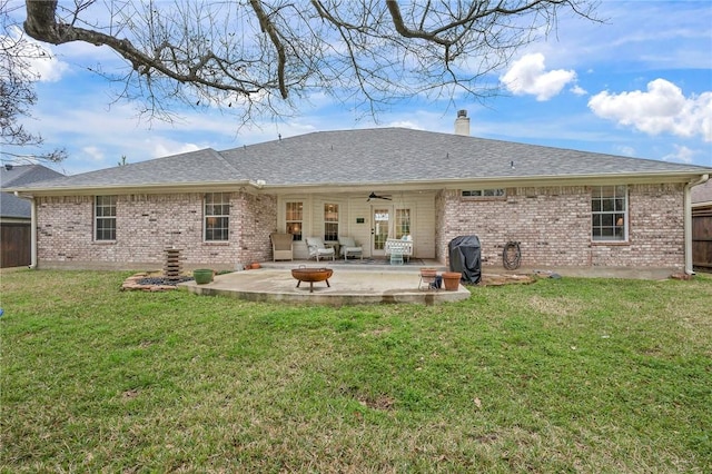 back of property with a patio, fence, a yard, brick siding, and a chimney