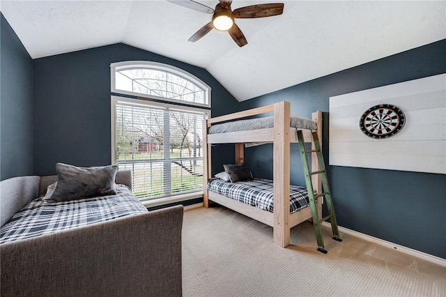 carpeted bedroom featuring lofted ceiling, multiple windows, baseboards, and ceiling fan