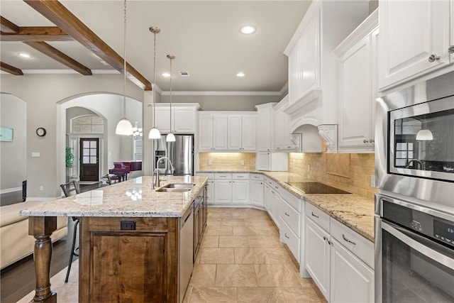 4507 Tonbridge Dr, College Station, TX 77845 - kitchen with appliances with stainless steel finishes, arched walkways, a sink, decorative backsplash, and recessed lighting