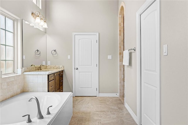 4507 Tonbridge Dr, College Station, TX 77845 - full bathroom with vanity, a garden tub, healthy amount of natural light, and baseboards
