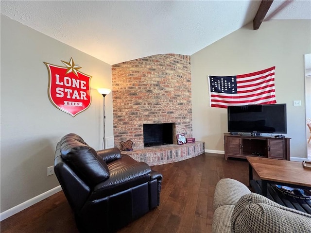 living room with dark hardwood / wood-style flooring, vaulted ceiling with beams, a fireplace, and a textured ceiling