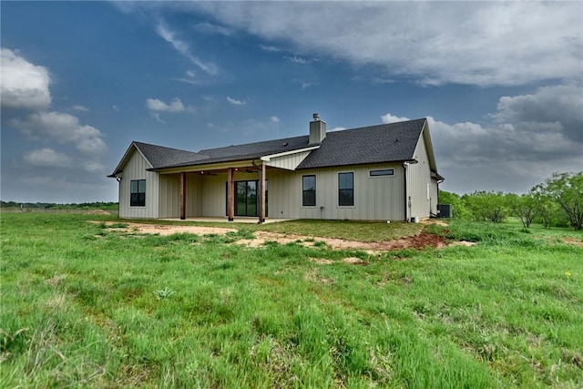 back of house featuring a chimney, a shingled roof, a ceiling fan, and a patio area