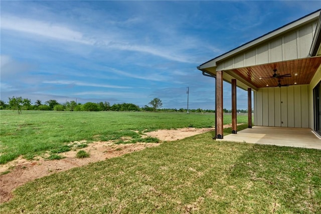 view of yard with a rural view, a ceiling fan, and a patio