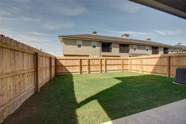 view of yard featuring a fenced backyard and central AC