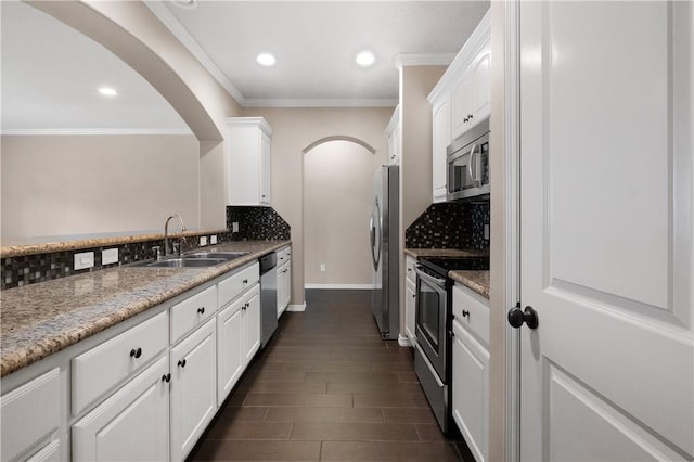 1403 Crescent Ridge Dr, College Station, TX 77845 - kitchen with appliances with stainless steel finishes, white cabinetry, tasteful backsplash, arched walkways, and ornamental molding
