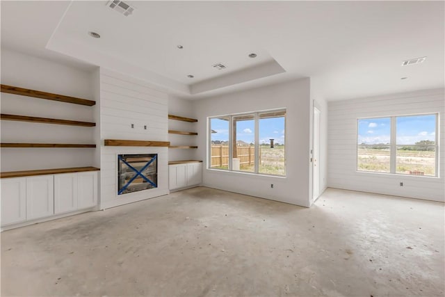 2814 Spector Dr, Bryan, TX 77808 - unfurnished living room with concrete floors, a raised ceiling, healthy amount of natural light, and a fireplace
