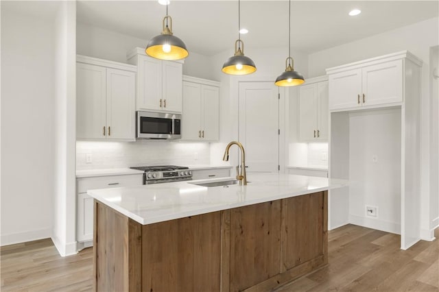 2814 Spector Dr, Bryan, TX 77808 - kitchen featuring appliances with stainless steel finishes, white cabinets, light wood-style flooring, light countertops, and recessed lighting