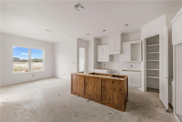 2814 Spector Dr, Bryan, TX 77808 - kitchen featuring a center island, concrete flooring, and white cabinets