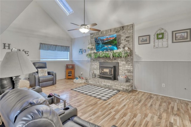 1681 Union Rd, Madisonville, TX 77864 - living room with a wood stove, wood finished floors, a wainscoted wall, vaulted ceiling, and a ceiling fan