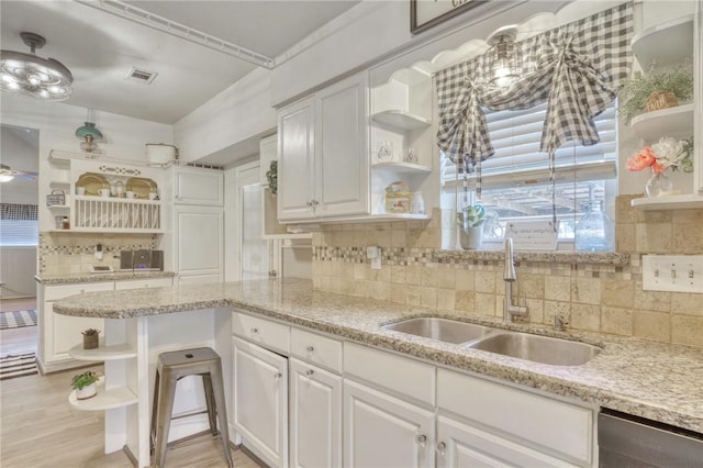 1681 Union Rd, Madisonville, TX 77864 - kitchen with open shelves, a sink, white cabinetry, and decorative backsplash