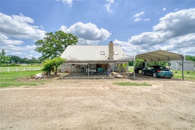 1681 Union Rd, Madisonville, TX 77864 - rear view of property featuring fence, a chimney, a carport, dirt driveway, and metal roof