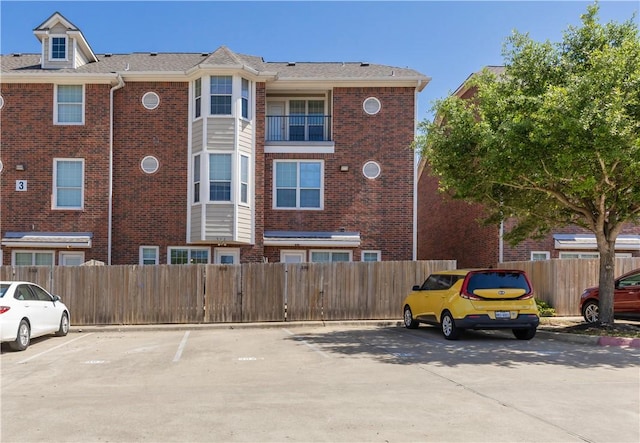view of property featuring uncovered parking and fence