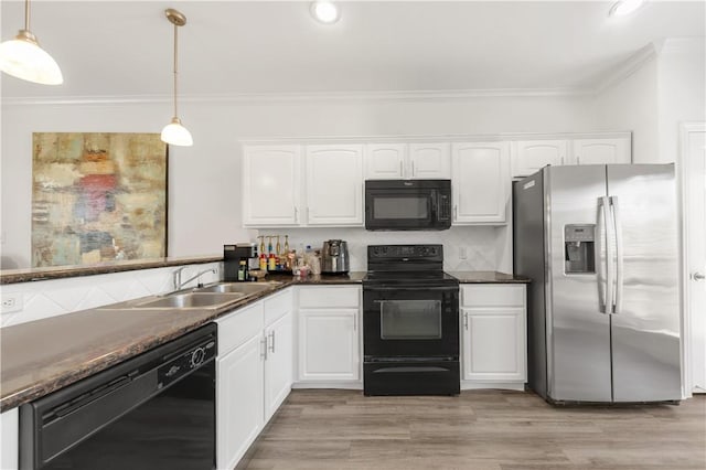 kitchen featuring white cabinets, a sink, black appliances, and ornamental molding