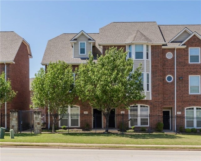 view of property with brick siding and a fenced front yard