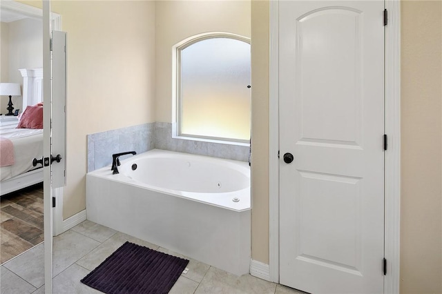 ensuite bathroom featuring a garden tub, connected bathroom, and tile patterned floors