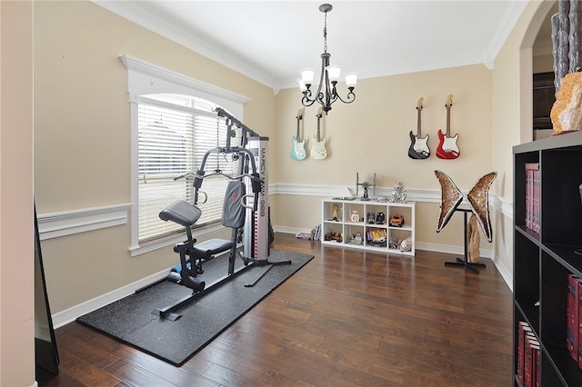 exercise room with a chandelier, ornamental molding, wood-type flooring, and baseboards