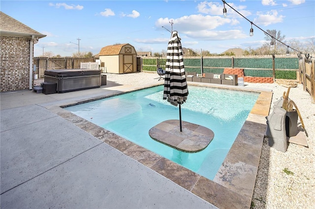 view of pool featuring a hot tub, a storage unit, a fenced backyard, and an outdoor structure