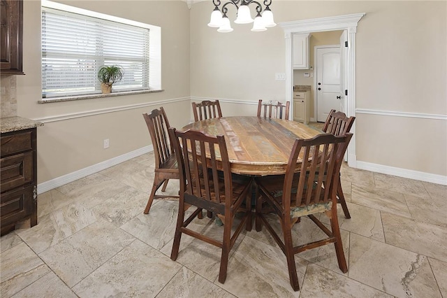 dining space with baseboards and a notable chandelier