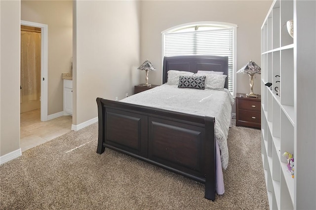 bedroom with light carpet, connected bathroom, and baseboards