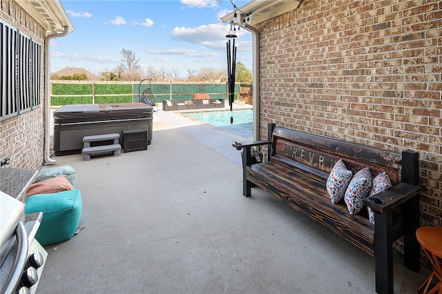 view of patio / terrace with a fenced backyard and a hot tub