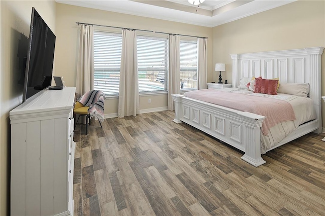 bedroom with multiple windows, crown molding, and light wood-style flooring