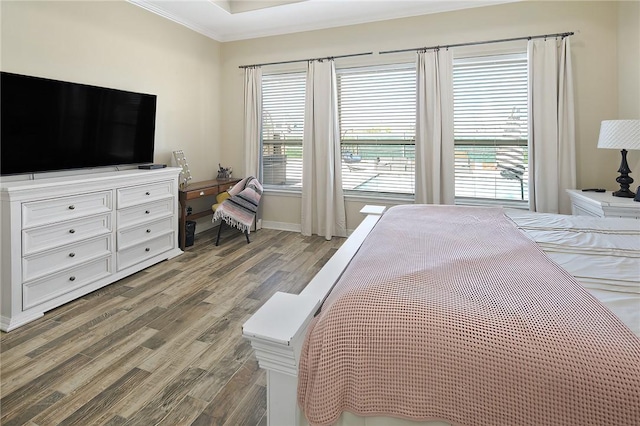 bedroom featuring wood finished floors and crown molding