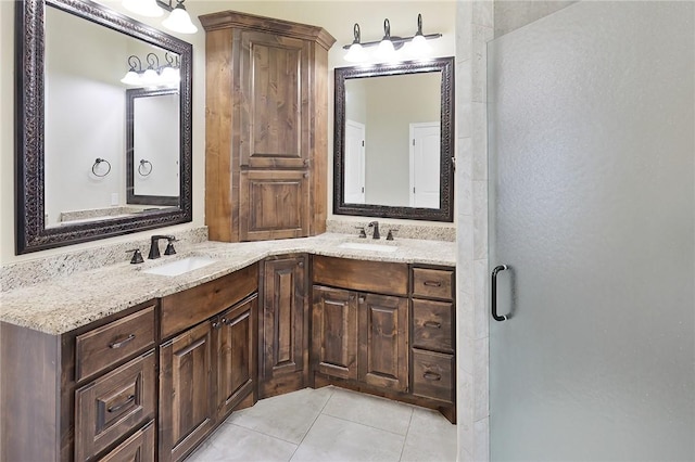 bathroom featuring tile patterned flooring, a shower with shower door, a sink, and double vanity