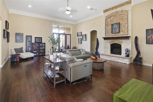 living room with ornamental molding, a large fireplace, and wood-type flooring