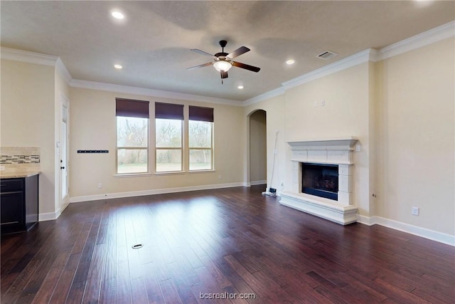 unfurnished living room featuring baseboards, visible vents, a fireplace with raised hearth, dark wood-style flooring, and ornamental molding