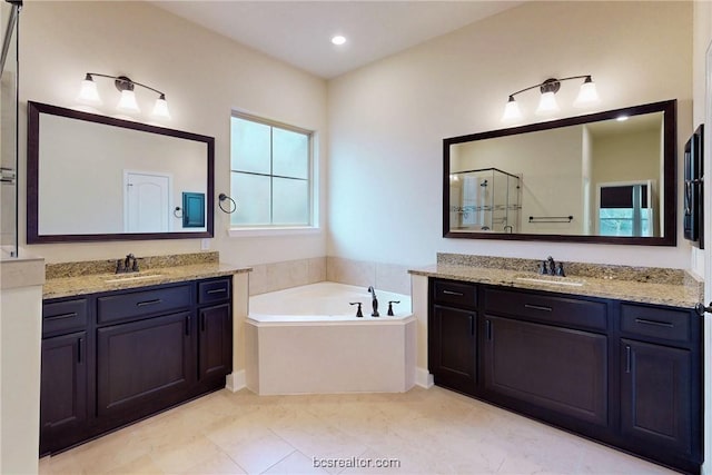 full bathroom with two vanities, a shower stall, a bath, and a sink