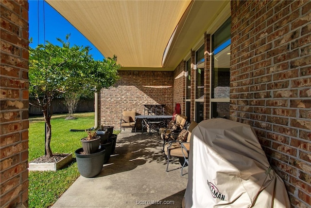 view of patio featuring fence and a grill