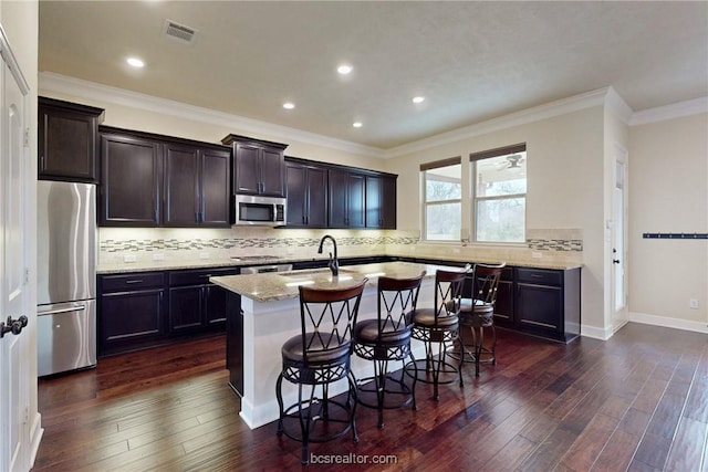 kitchen with dark wood-type flooring, visible vents, appliances with stainless steel finishes, and a sink