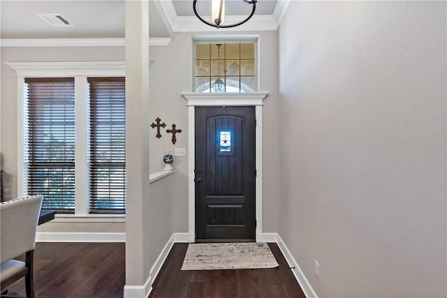 entryway featuring a notable chandelier, plenty of natural light, ornamental molding, and dark wood-type flooring