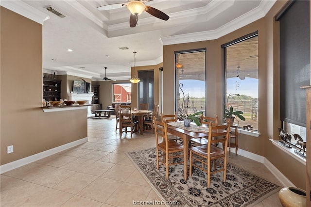 dining space featuring a tray ceiling, crown molding, light tile patterned flooring, and ceiling fan