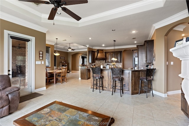 kitchen with custom exhaust hood, ornamental molding, and a breakfast bar area