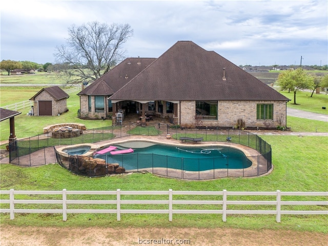 view of swimming pool featuring a storage shed, a yard, an in ground hot tub, a rural view, and a patio