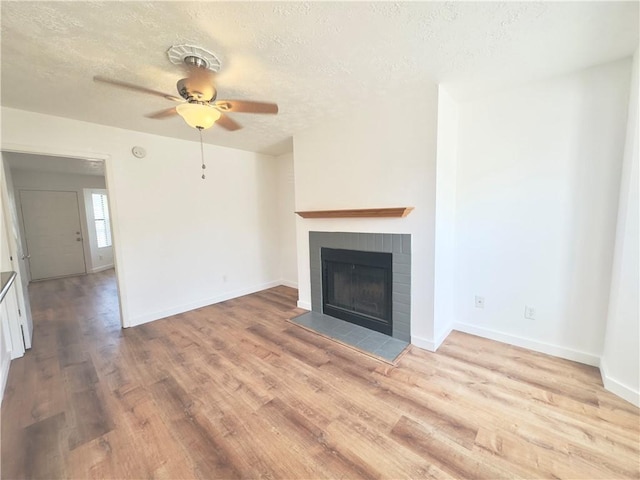 unfurnished living room with a textured ceiling, light hardwood / wood-style floors, and ceiling fan