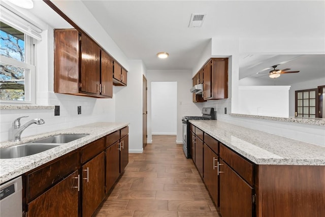 kitchen with dishwasher, stainless steel range with gas cooktop, sink, light hardwood / wood-style flooring, and tasteful backsplash