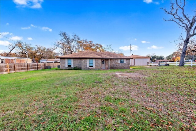 rear view of property with a yard, an outdoor structure, and a garage