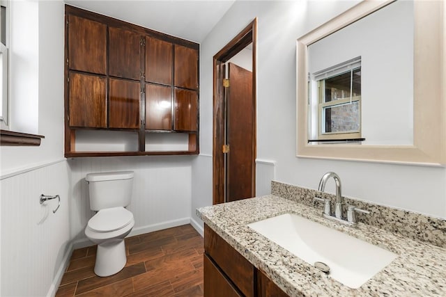 bathroom with vanity, toilet, and wood-type flooring