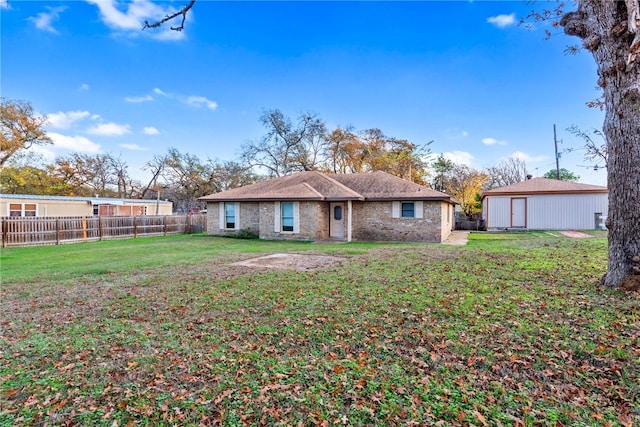 rear view of house with a yard, an outbuilding, and a garage