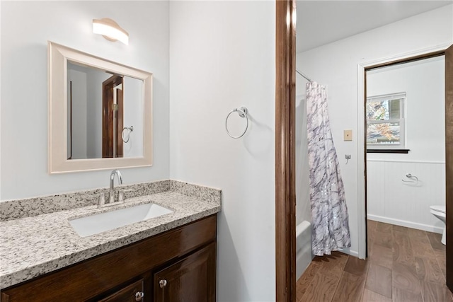 full bathroom featuring hardwood / wood-style flooring, vanity, toilet, and shower / bathtub combination with curtain