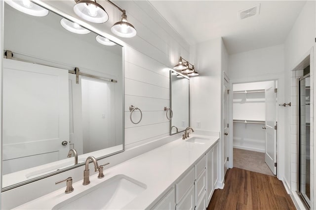 bathroom featuring vanity, hardwood / wood-style flooring, and a shower with door