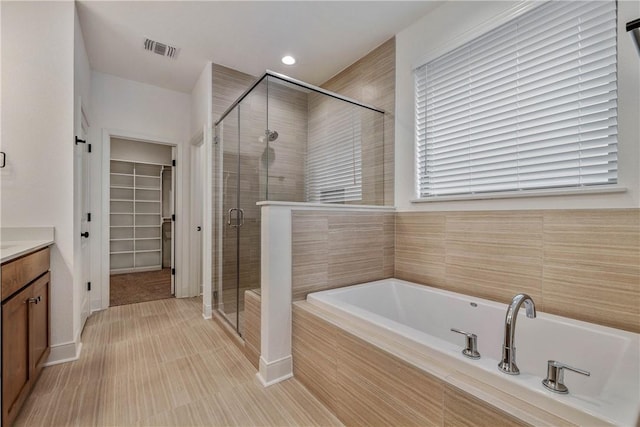 bathroom with plus walk in shower and vanity