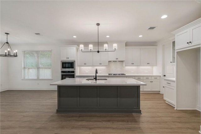 kitchen featuring white cabinets, hanging light fixtures, sink, and appliances with stainless steel finishes